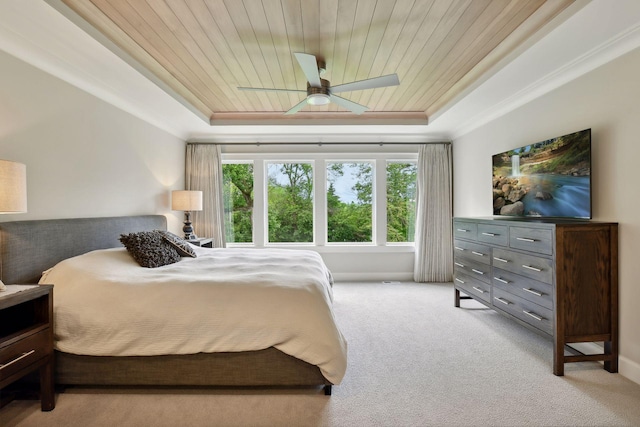 carpeted bedroom with wood ceiling, a raised ceiling, and ornamental molding