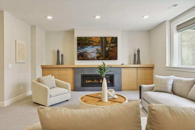 living room featuring visible vents, baseboards, recessed lighting, a tile fireplace, and carpet flooring