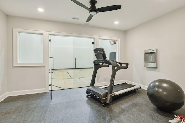 exercise area featuring visible vents, baseboards, carpet, and a ceiling fan