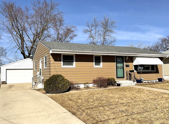 view of front of house featuring entry steps, an outbuilding, a detached garage, and roof with shingles