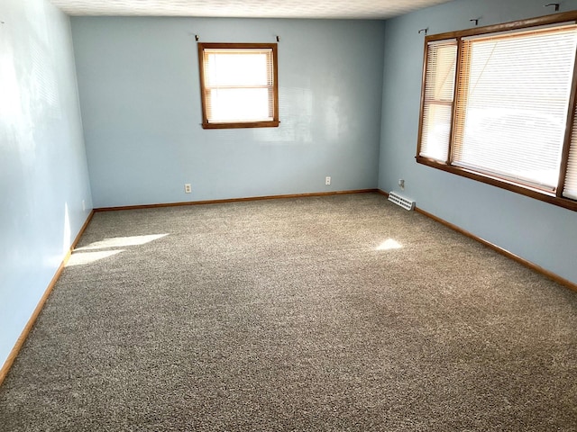 empty room with baseboards and visible vents