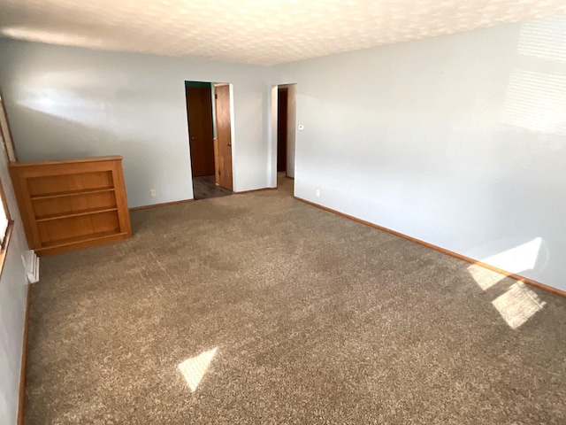 unfurnished bedroom featuring baseboards, a textured ceiling, and carpet floors