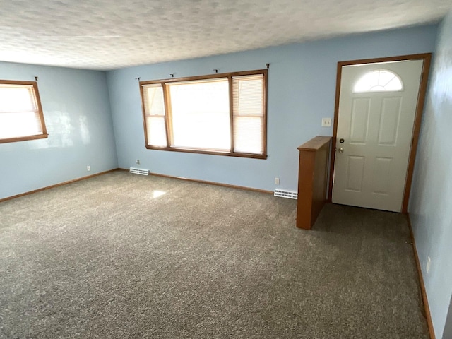 interior space featuring baseboards, carpet floors, a textured ceiling, and visible vents