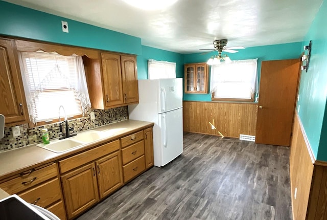 kitchen with a sink, dark wood-style floors, brown cabinetry, and freestanding refrigerator