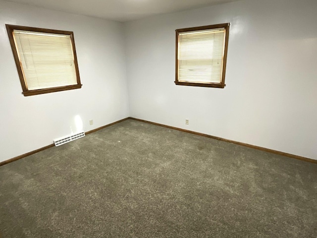 carpeted spare room with visible vents and baseboards