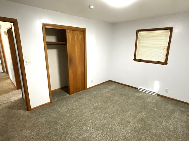 unfurnished bedroom with baseboards, visible vents, a closet, and carpet floors