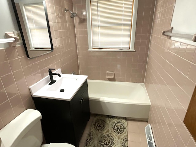 full bathroom featuring visible vents, toilet, vanity, tile patterned floors, and tile walls