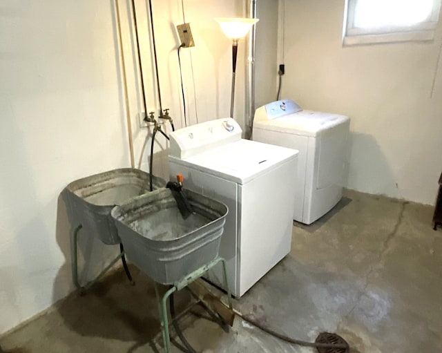 clothes washing area with a sink, separate washer and dryer, and laundry area