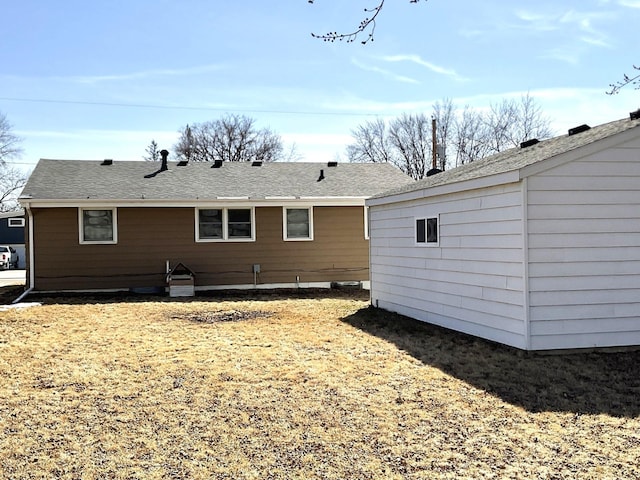 rear view of property featuring a shingled roof