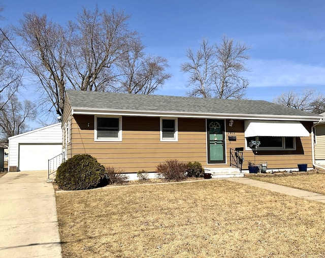 view of front of home with a garage, a shingled roof, an outdoor structure, and a front yard