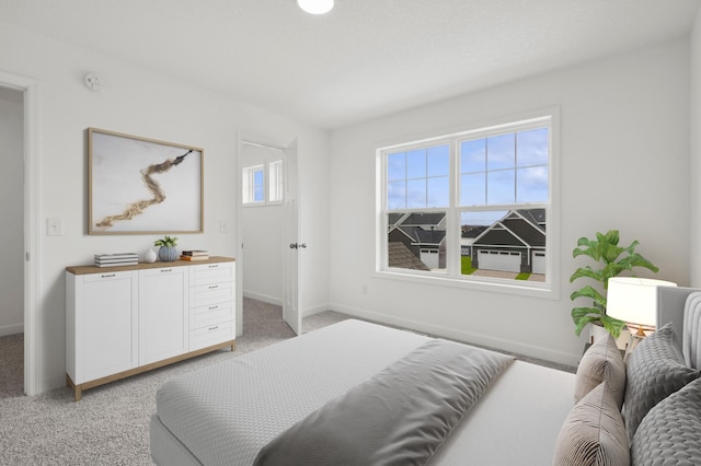 bedroom featuring light colored carpet and baseboards