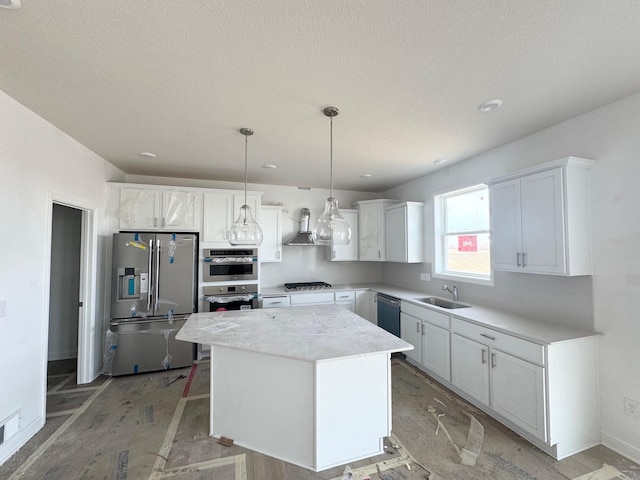 kitchen featuring a kitchen island, a sink, stainless steel appliances, white cabinets, and wall chimney range hood