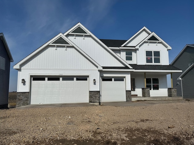 craftsman house with a garage, stone siding, board and batten siding, and dirt driveway