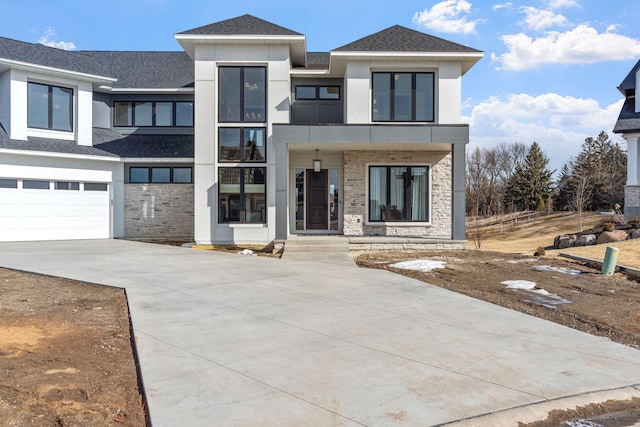 view of front facade with stucco siding, stone siding, driveway, and a shingled roof