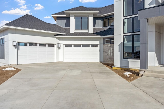 view of front facade featuring a garage, concrete driveway, stucco siding, and a shingled roof