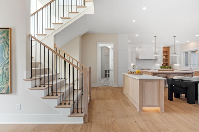 kitchen featuring tasteful backsplash, light brown cabinets, light countertops, recessed lighting, and light wood-style floors