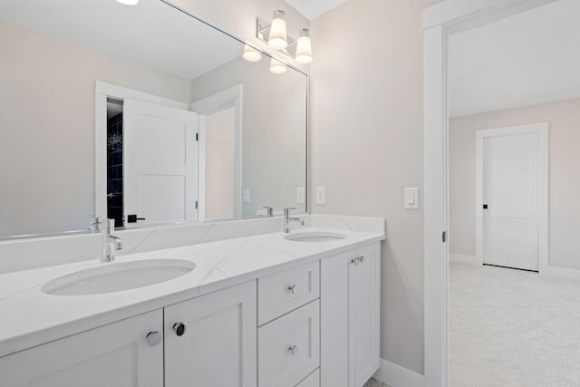 bathroom with double vanity, baseboards, and a sink