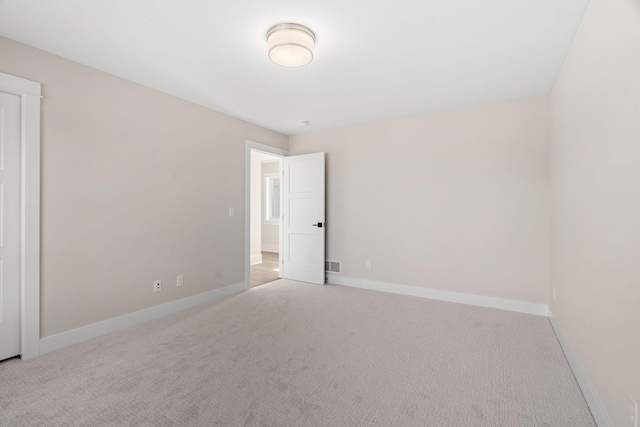 carpeted empty room featuring visible vents and baseboards