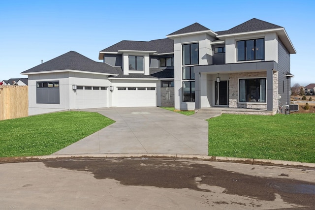 view of front of house featuring driveway, roof with shingles, an attached garage, and central AC