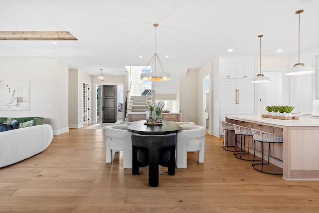 dining area with stairs, recessed lighting, light wood-type flooring, and baseboards