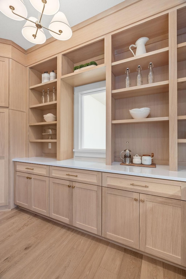 detailed view of wood finished floors and a chandelier