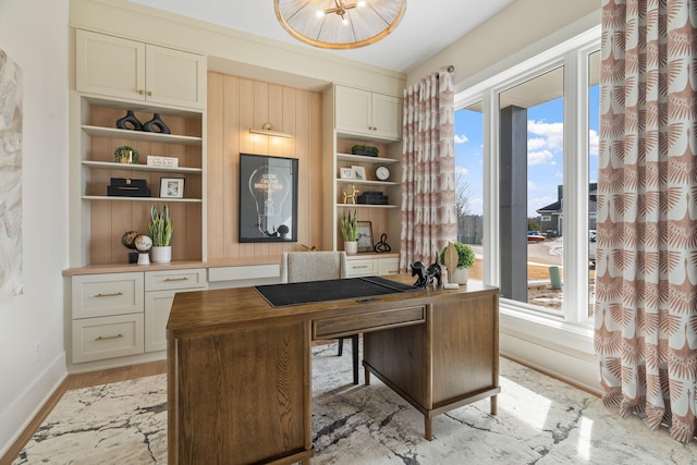 home office featuring baseboards, plenty of natural light, built in features, and light wood-style floors