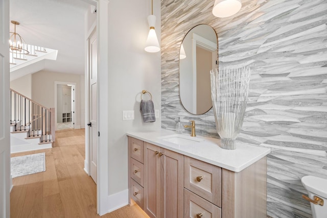 bathroom with wood finished floors, vanity, and baseboards