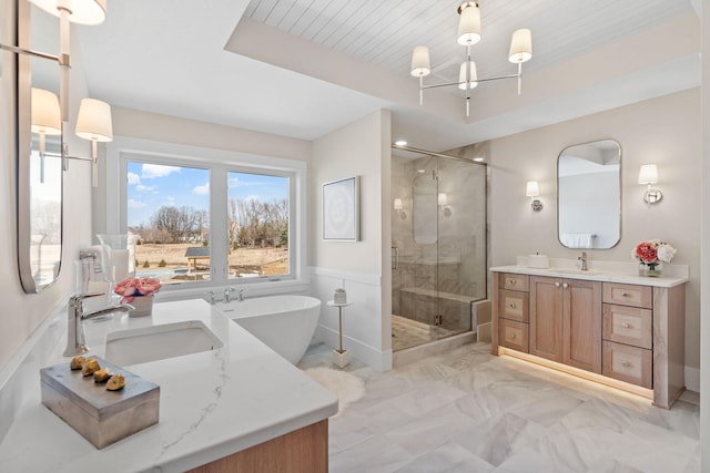 bathroom with a shower stall, marble look tiles, vanity, and a freestanding tub