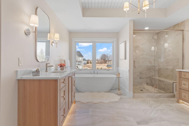 full bath featuring a shower stall, vanity, a freestanding bath, and marble finish flooring