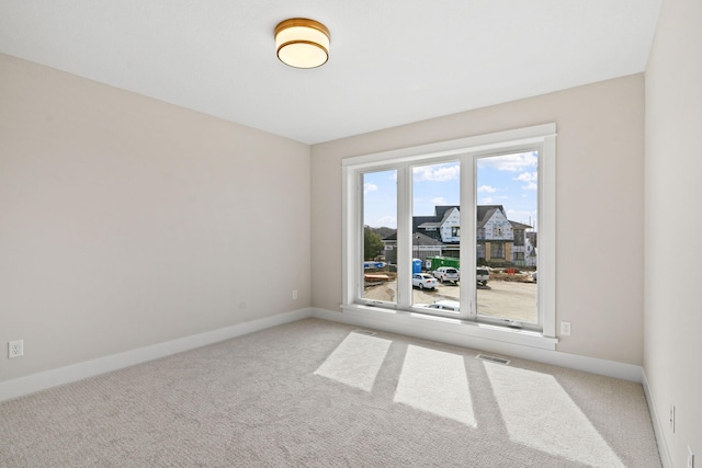 unfurnished room featuring carpet and baseboards