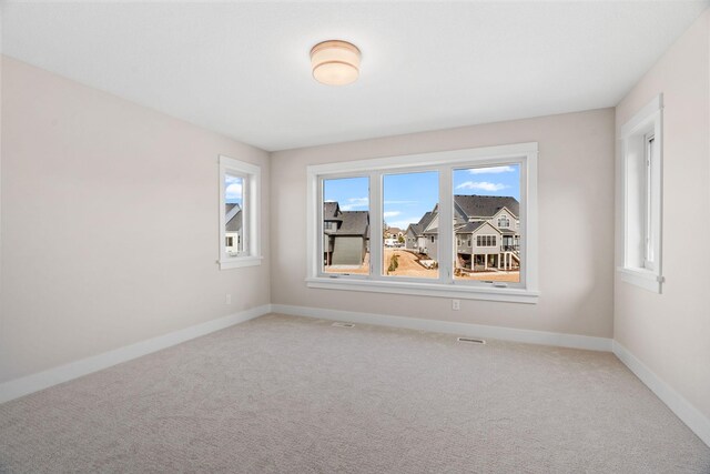 spare room featuring carpet floors and baseboards