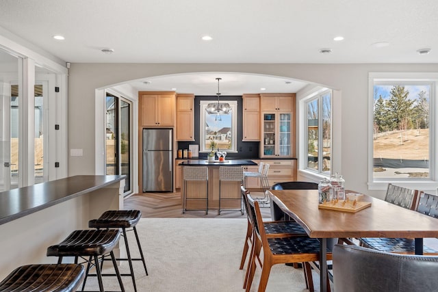 dining room with arched walkways, a chandelier, and recessed lighting