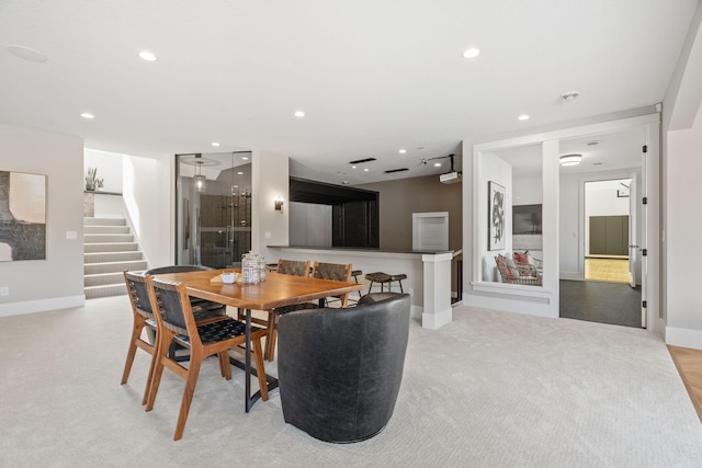 dining area with stairs, recessed lighting, baseboards, and light colored carpet