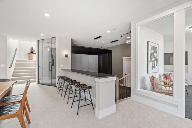kitchen with carpet floors, recessed lighting, and a kitchen breakfast bar