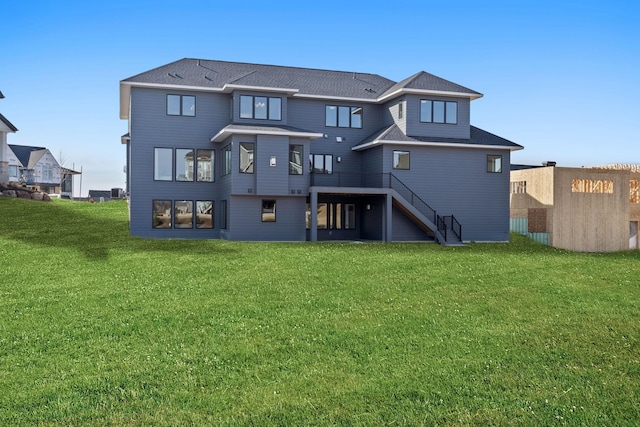 rear view of property with stairs and a yard