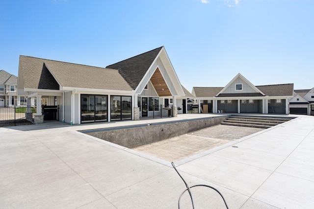 view of building exterior featuring fence and a community pool