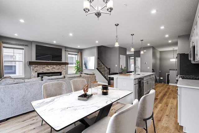 dining room featuring light wood-style flooring, a chandelier, recessed lighting, and stairs