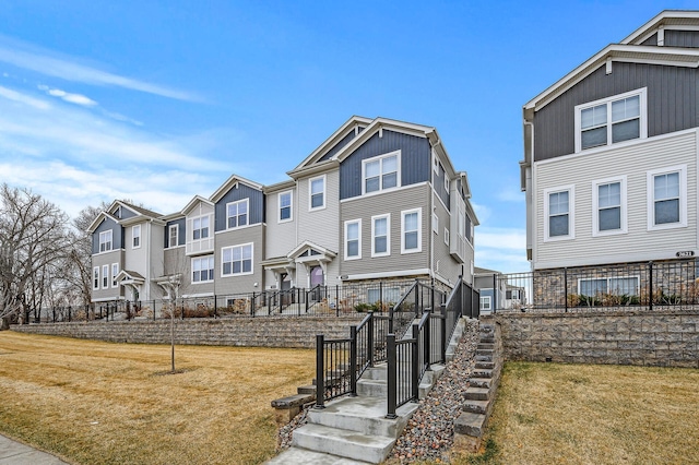 view of front of property with fence, a front lawn, and a residential view