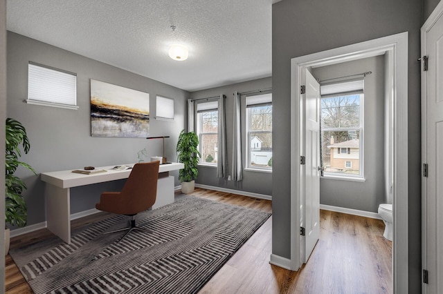 office area featuring wood finished floors, baseboards, and a textured ceiling