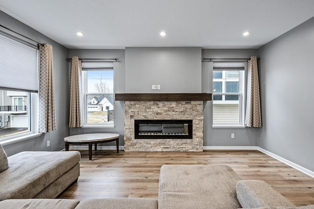 living room with baseboards, a healthy amount of sunlight, wood finished floors, and a fireplace