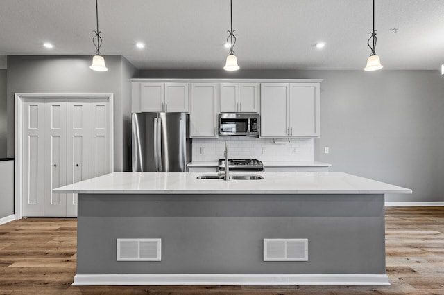 kitchen featuring visible vents, appliances with stainless steel finishes, baseboards, and decorative backsplash