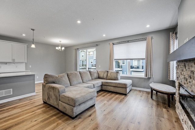 living area featuring recessed lighting, an inviting chandelier, visible vents, baseboards, and light wood-style flooring