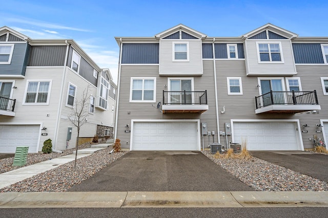 view of property featuring driveway, cooling unit, and a garage