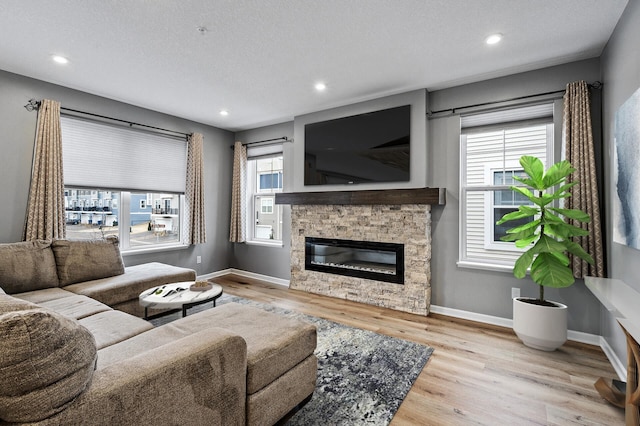 living room featuring baseboards, wood finished floors, and plenty of natural light
