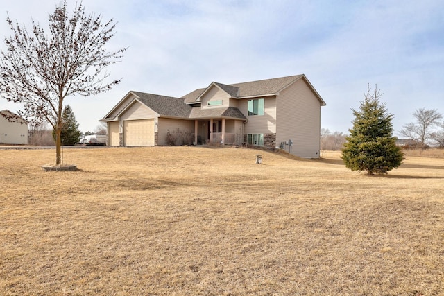 view of front of property featuring an attached garage and a front lawn