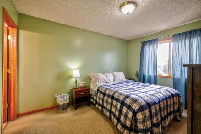 bedroom with carpet flooring, baseboards, and a textured ceiling