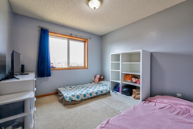 bedroom with carpet, baseboards, and a textured ceiling