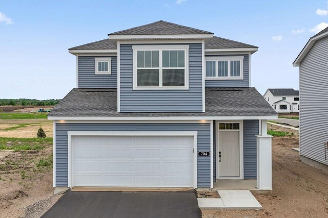 704 Highland Cir, Jordan, MN 55352 - traditional-style home with roof with shingles, driveway, and a garage