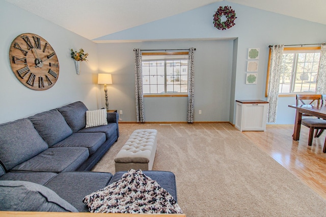 living room featuring baseboards, light wood-style floors, and lofted ceiling