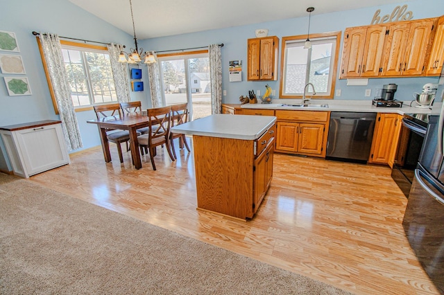 kitchen with a kitchen island, a sink, light countertops, vaulted ceiling, and stainless steel dishwasher